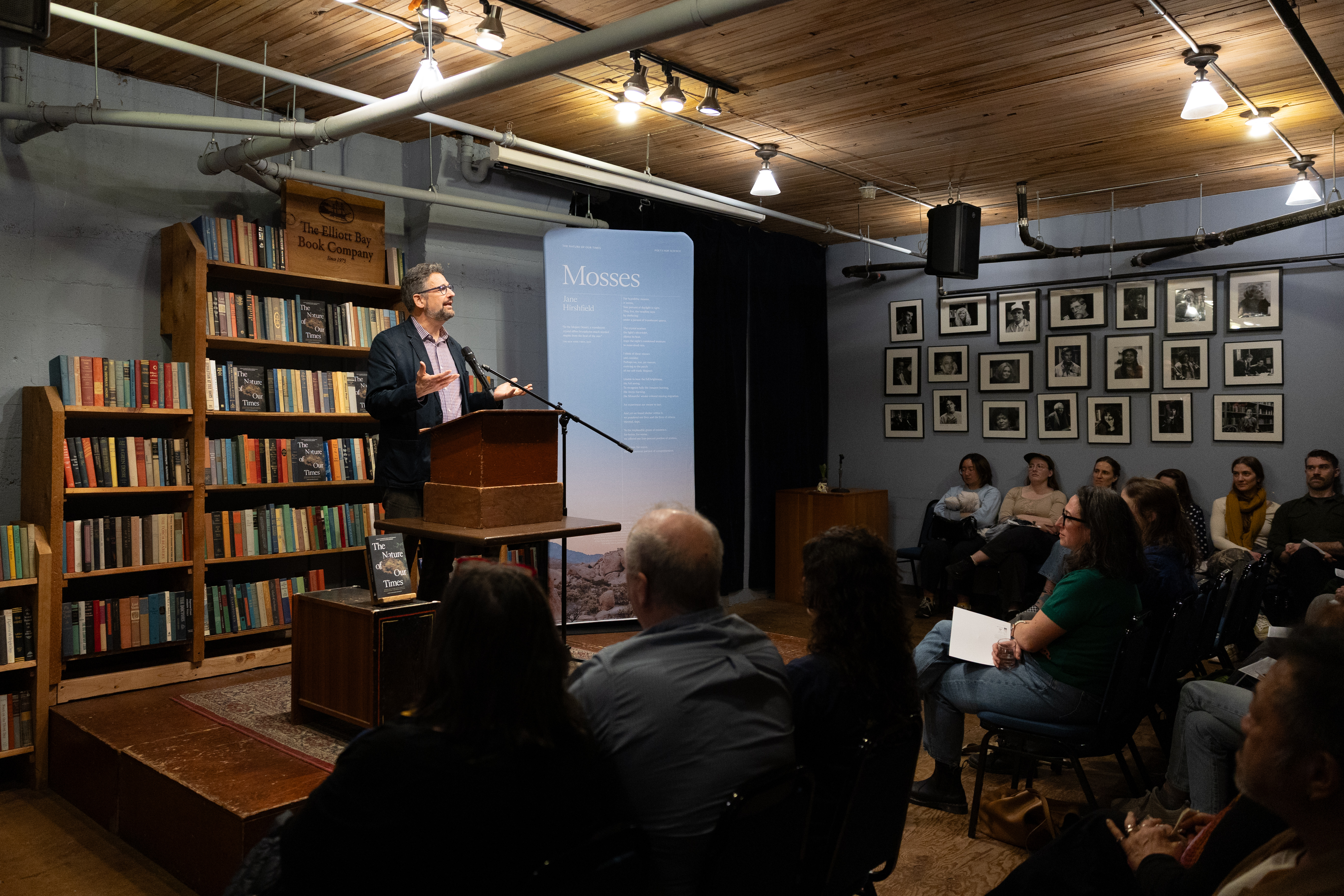 Speaker at podium during The Nature of Our Times poetry reading at Elliott Bay Book Company